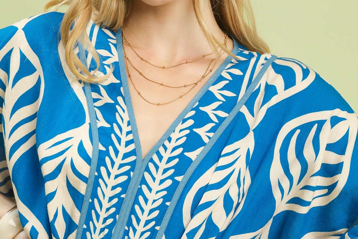 Woman wearing a blue and white patterned dress against a light green background